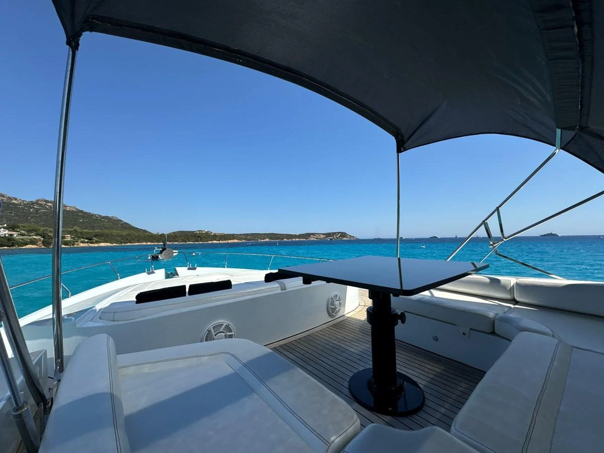 The flybridge offers a shaded seating area with a table, perfect for enjoying the scenic views. aboard THYKE III Yacht for Sale