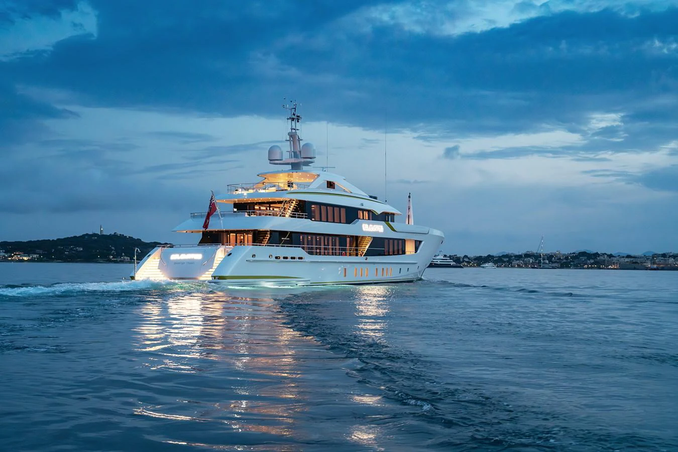 A luxurious yacht glides gracefully on calm waters against a serene evening backdrop. aboard SOLEMATES Yacht for Sale