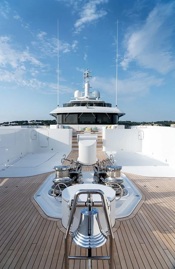 A pristine deck area with polished fittings and a clear view towards the yacht's superstructure under a bright blue sky. aboard SOLEMATES Yacht for Sale