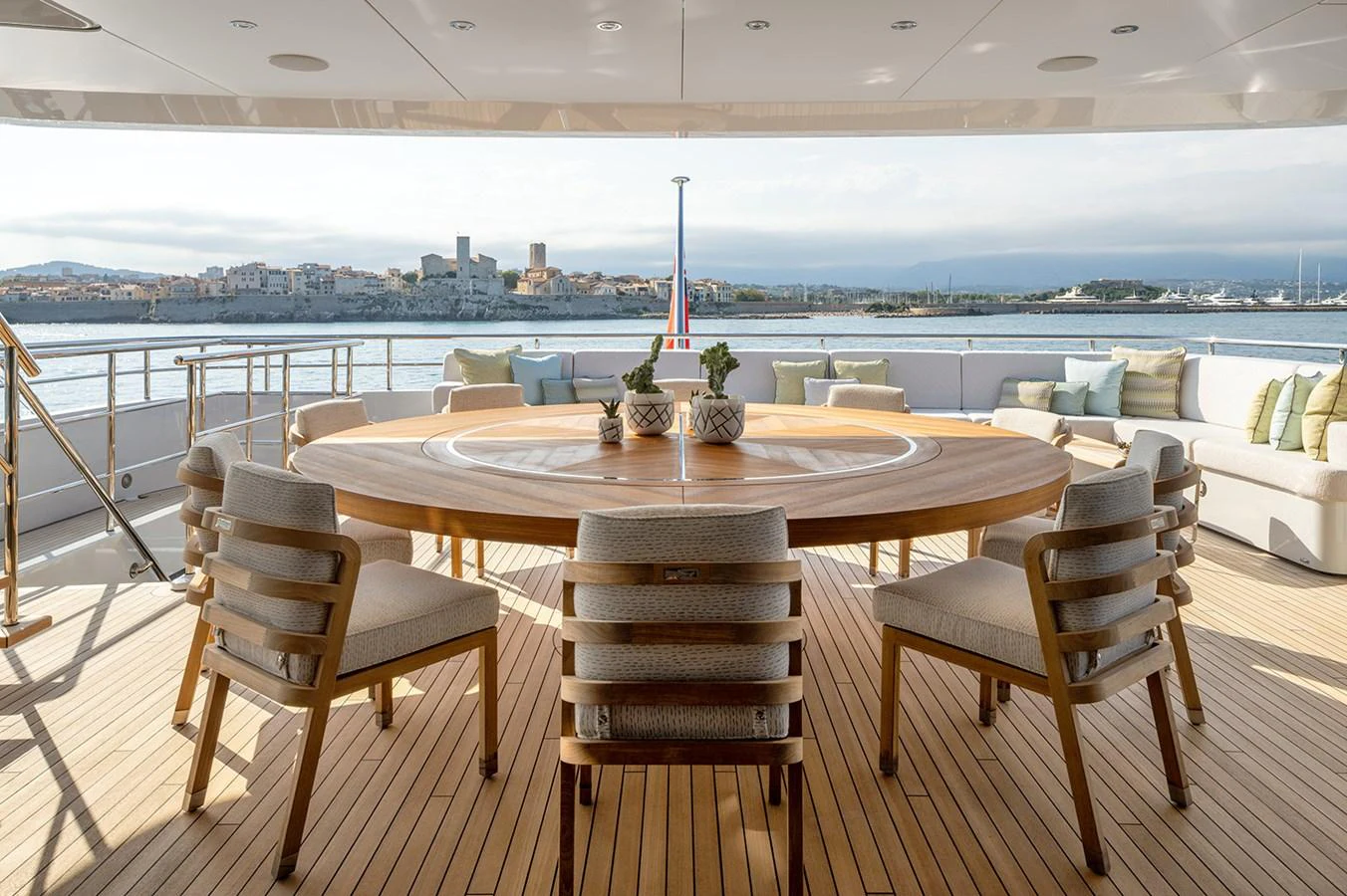 The aft deck features a spacious dining area with a large round table and comfortable seating, perfect for alfresco dining with a view. aboard SOLEMATES Yacht for Sale