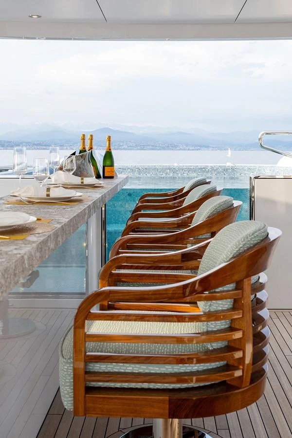 The yacht's bar area features elegant seating with a stunning ocean view. aboard SOLEMATES Yacht for Sale