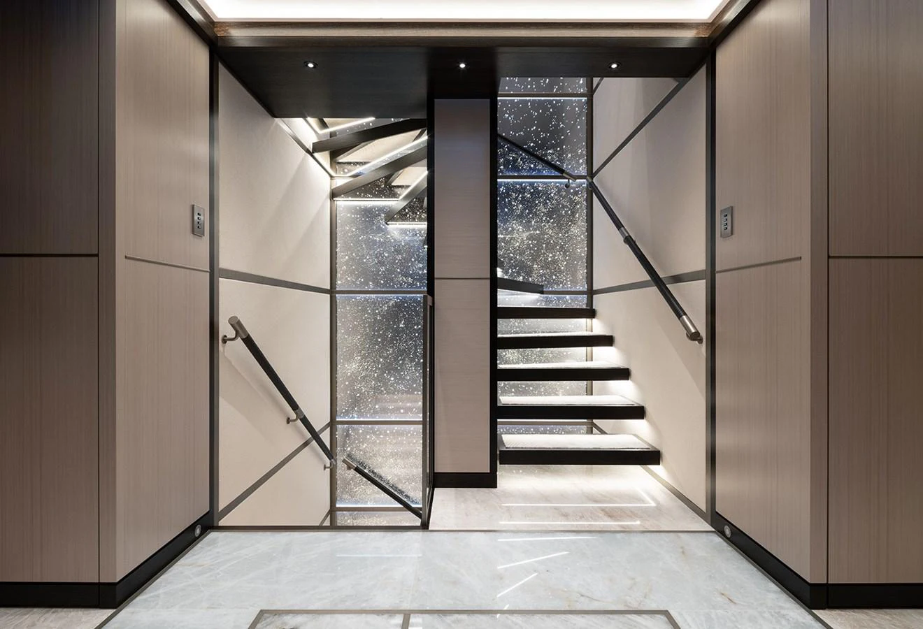 A sleek and modern staircase with illuminated steps and mirrored walls. aboard SOLEMATES Yacht for Sale