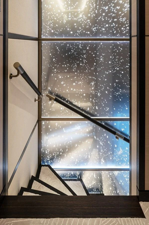 A beautifully designed staircase with a stunning illuminated backdrop. aboard SOLEMATES Yacht for Sale