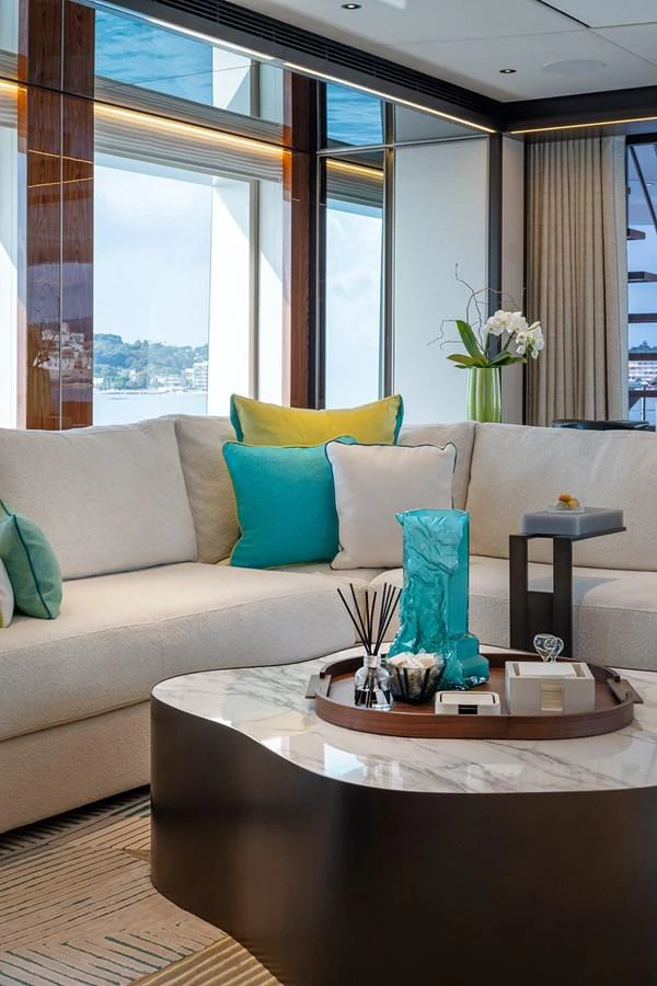 The salon features a comfortable seating area with stylish decor and large windows offering scenic views. aboard SOLEMATES Yacht for Sale