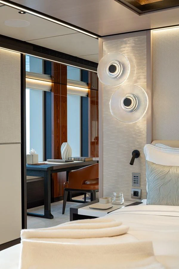 The stateroom features elegant decor with modern lighting and a comfortable workspace. aboard SOLEMATES Yacht for Sale