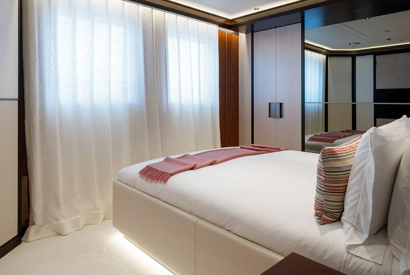The stateroom features a plush bed with elegant linens and soft lighting, creating a serene and inviting atmosphere. aboard SOLEMATES Yacht for Sale
