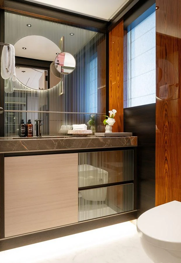 The yacht's bathroom features modern fixtures and elegant wood paneling. aboard SOLEMATES Yacht for Sale