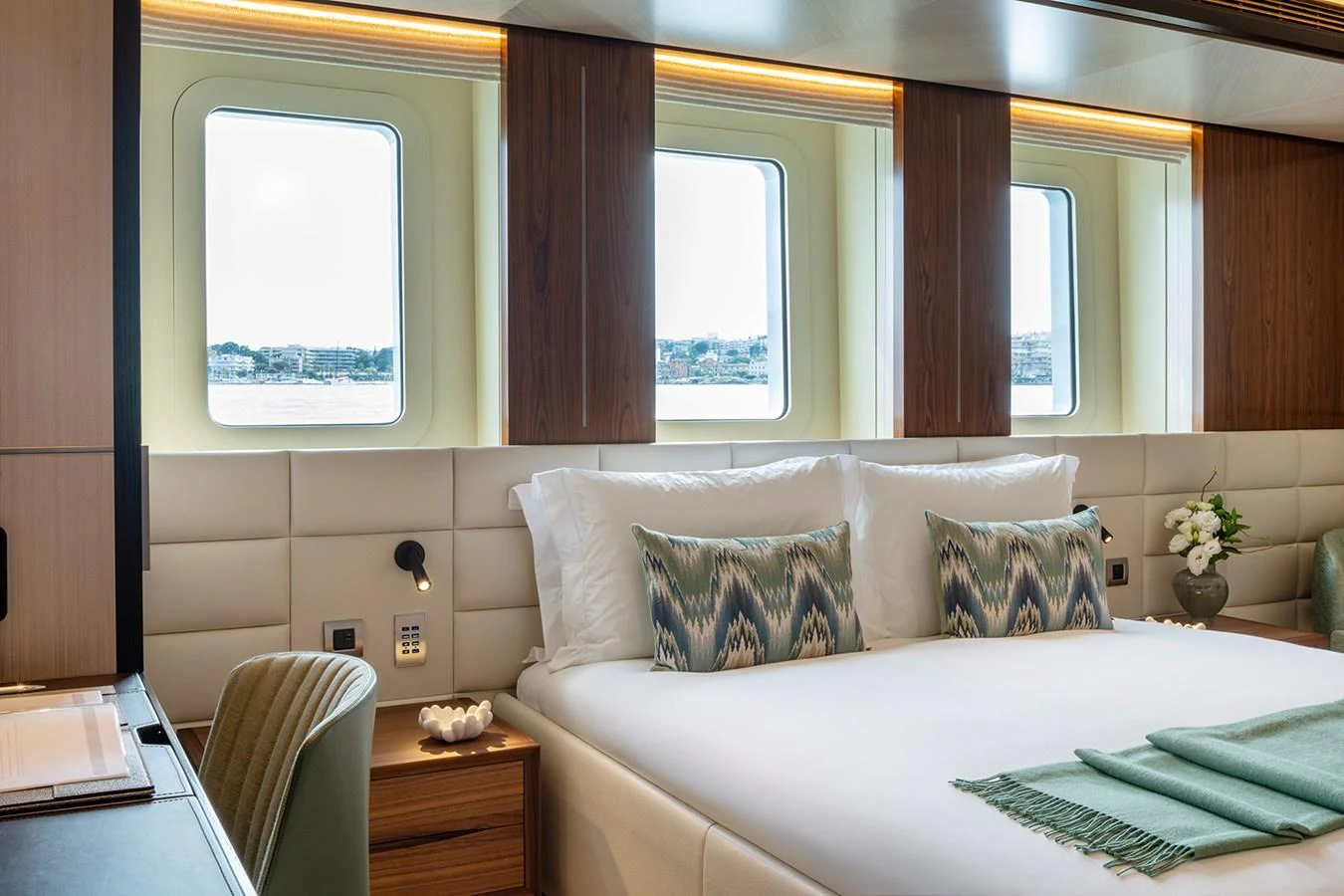 The stateroom features a luxurious bed with elegant decor and large windows offering a scenic view. aboard SOLEMATES Yacht for Sale