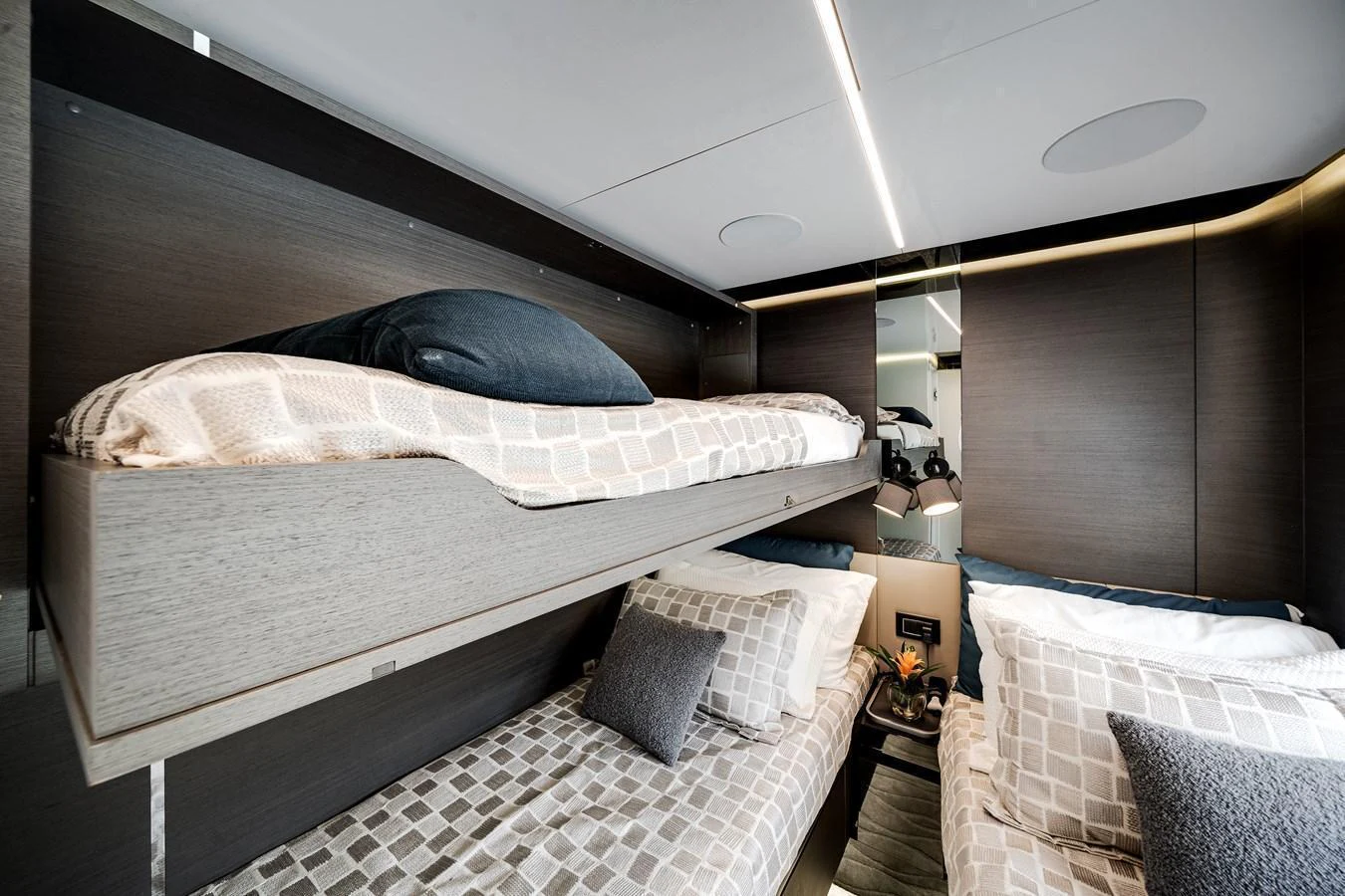 The guest cabin features cozy bunk beds with modern bedding and a sleek design. aboard PARTNERSHIP V Yacht for Sale