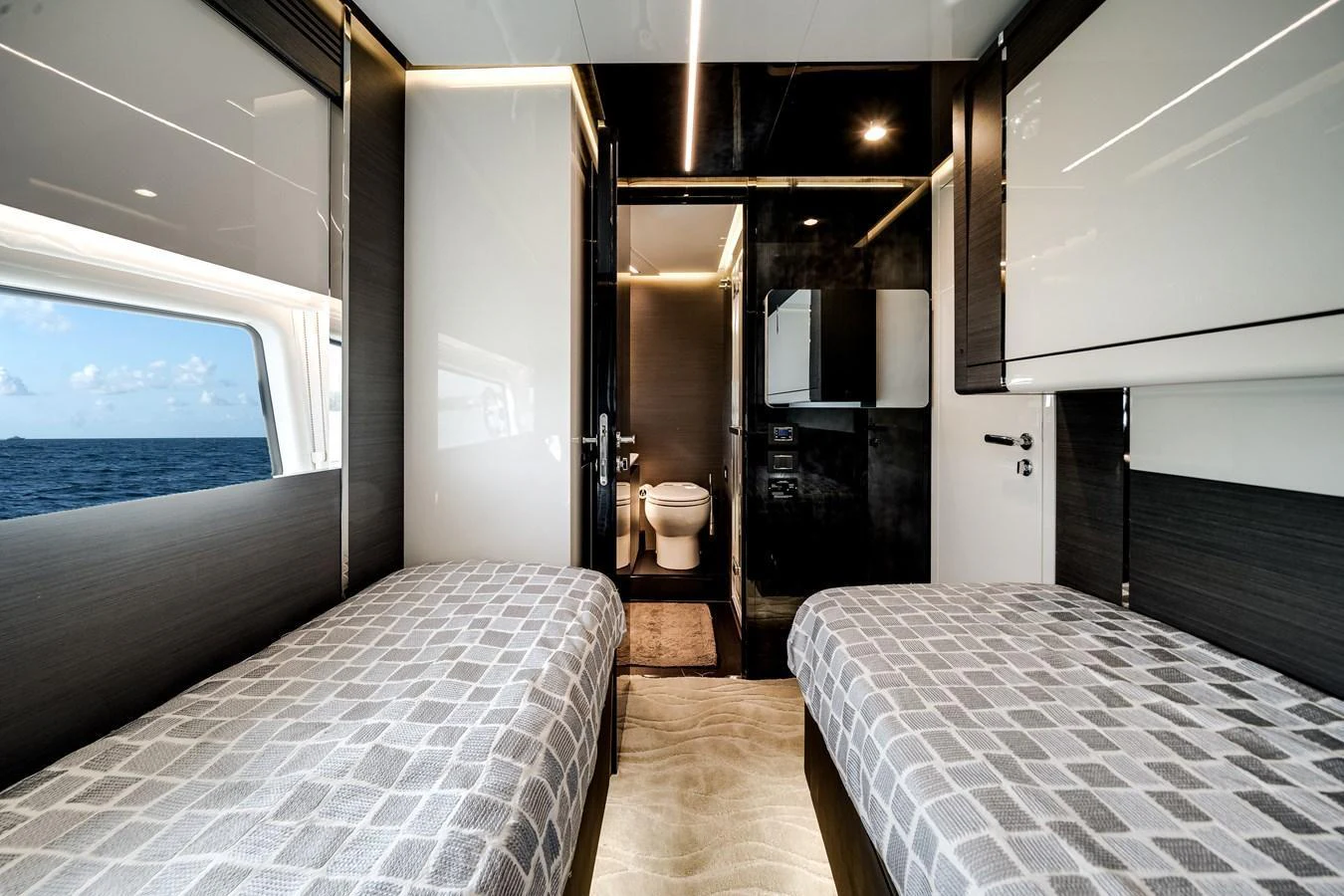 A modern twin stateroom with sleek finishes and an en-suite bathroom. aboard PARTNERSHIP V Yacht for Sale