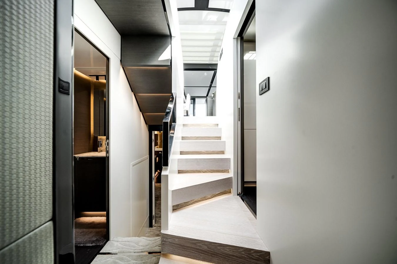 A modern and sleek interior staircase with a skylight above, leading to different levels of the yacht. aboard PARTNERSHIP V Yacht for Sale
