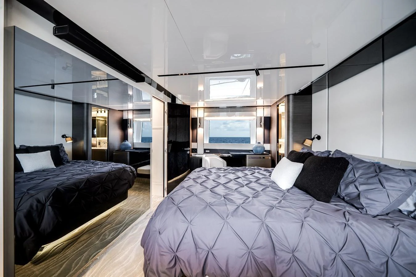 A luxurious stateroom featuring a plush bed with a view of the sea through large windows. aboard PARTNERSHIP V Yacht for Sale