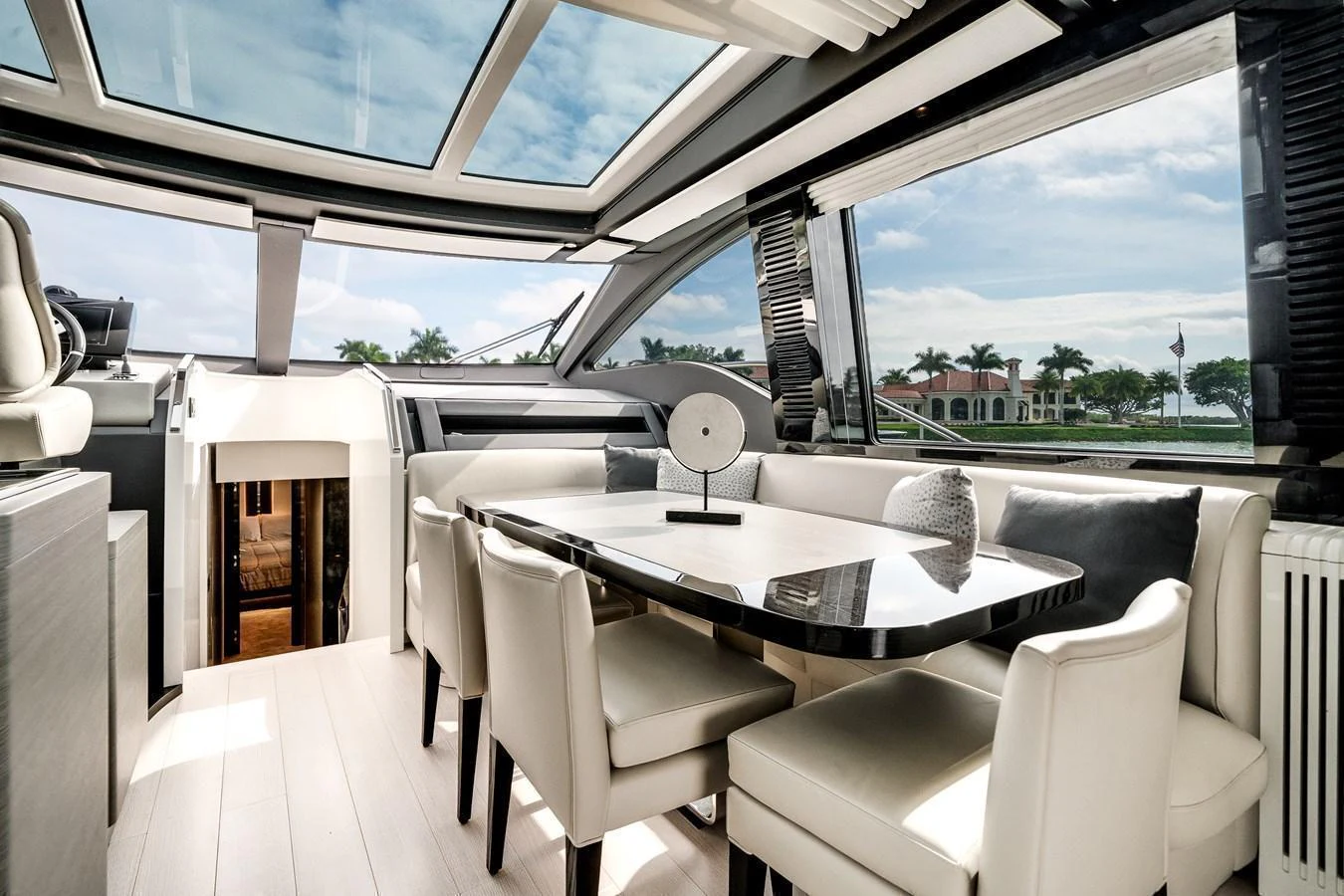 The yacht's dining area features a sleek table with plush seating and panoramic views through large windows. aboard PARTNERSHIP V Yacht for Sale