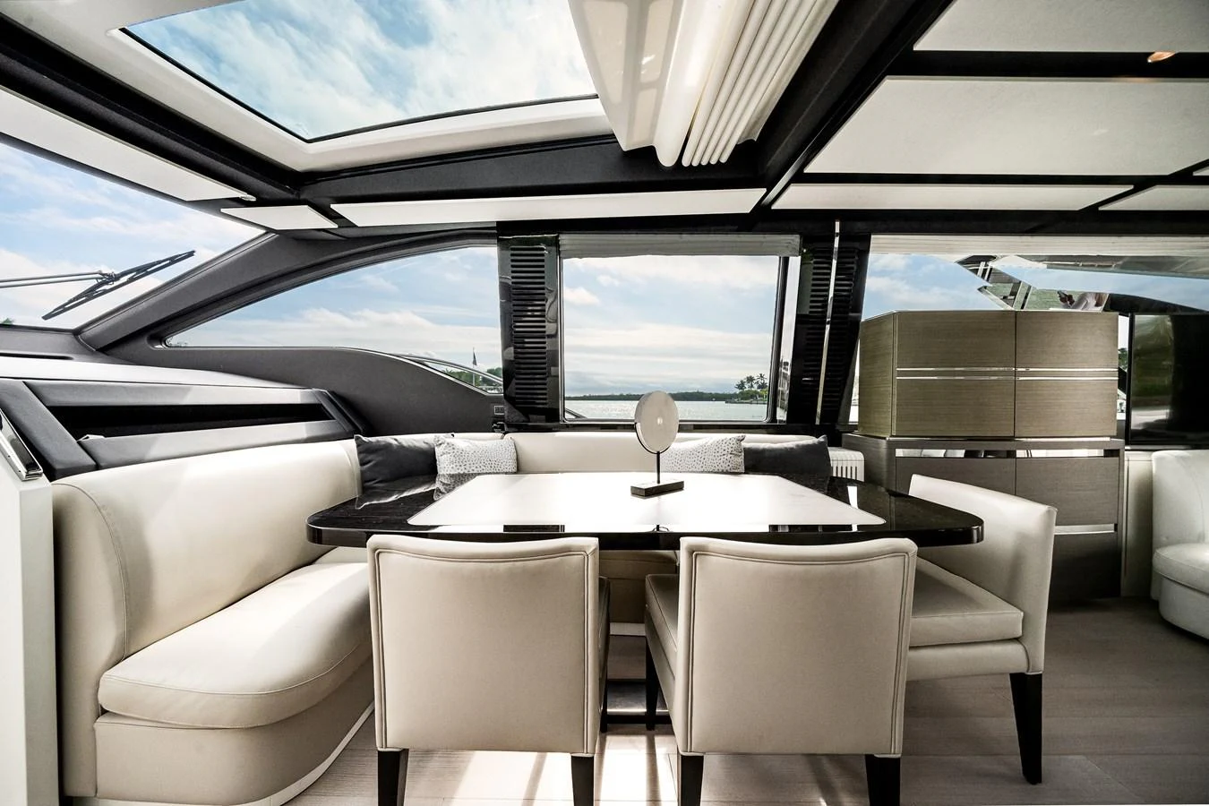 The yacht's dining area features a sleek, modern design with ample natural light from large windows and skylights. aboard PARTNERSHIP V Yacht for Sale
