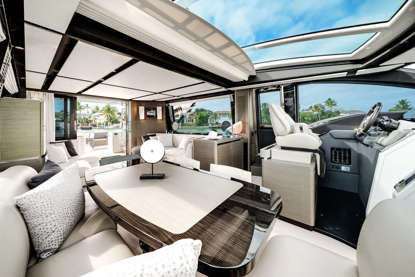 The yacht's salon features luxurious seating, a sleek dining table, and expansive windows for panoramic views. aboard PARTNERSHIP V Yacht for Sale