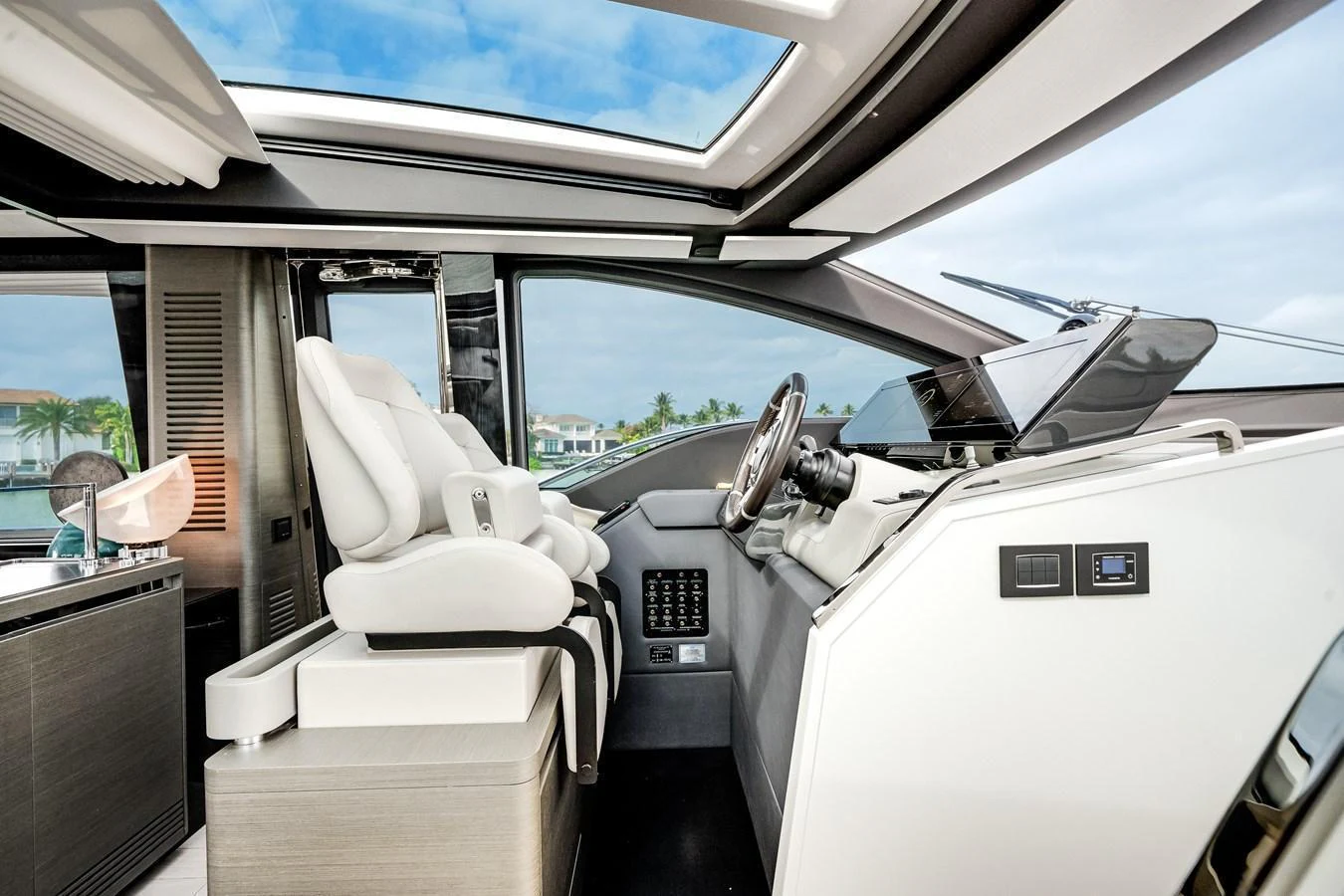 The helm station features modern controls and a panoramic view through large windows and a skylight. aboard PARTNERSHIP V Yacht for Sale