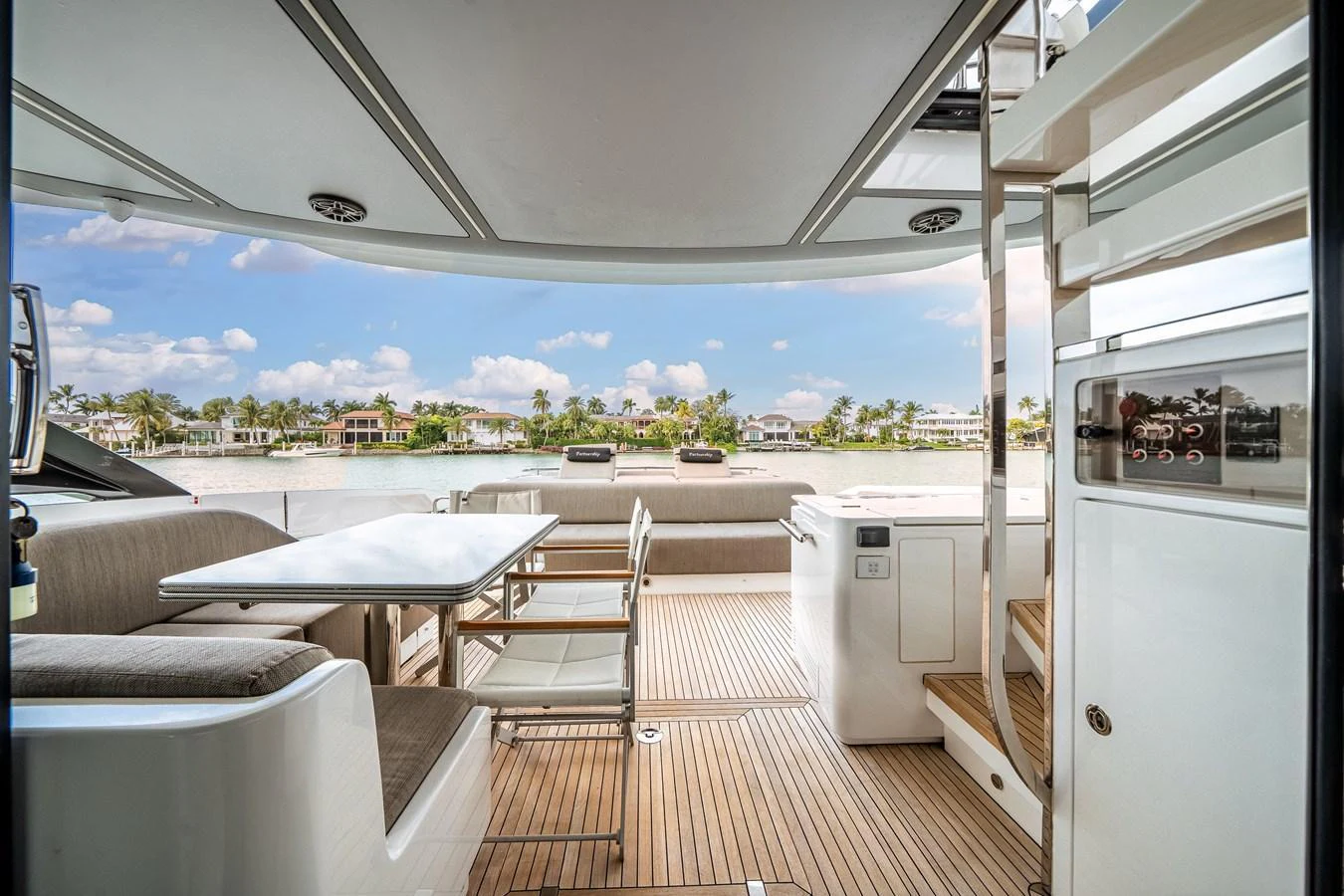 The aft deck features a comfortable dining area with a scenic view of the water and surrounding landscape. aboard PARTNERSHIP V Yacht for Sale
