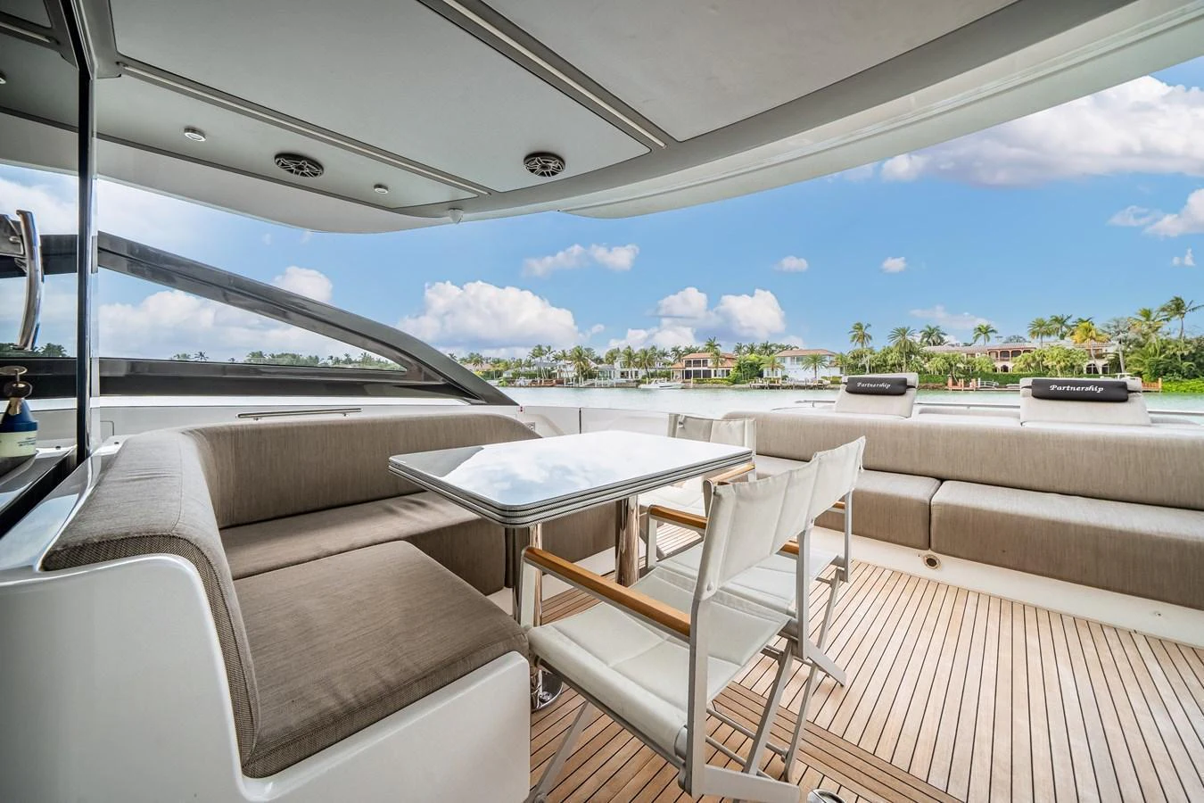 The aft deck features a stylish dining area with comfortable seating and a beautiful view. aboard PARTNERSHIP V Yacht for Sale