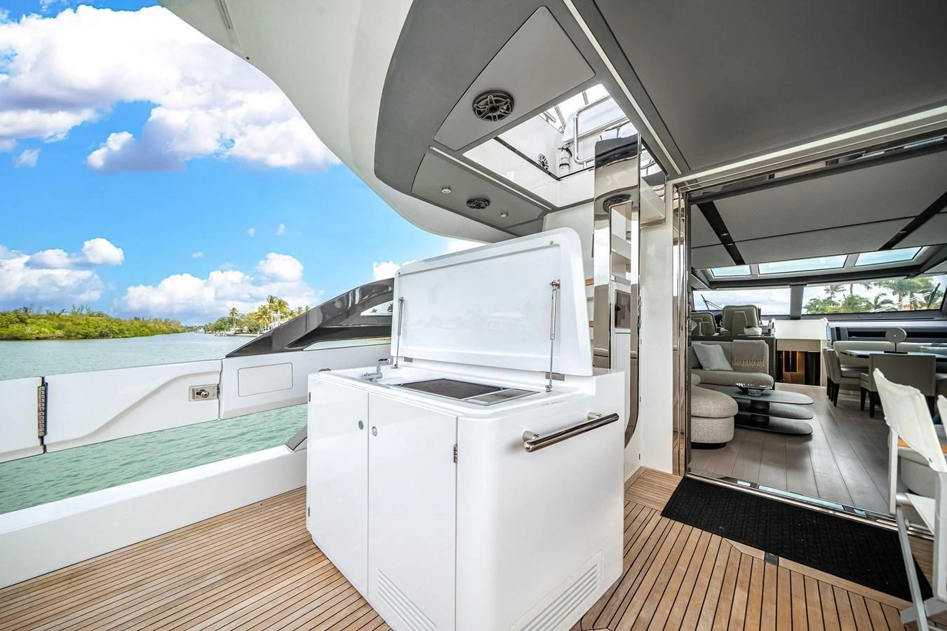 The aft deck features a sleek, modern design with a view of the water and access to the interior living space. aboard PARTNERSHIP V Yacht for Sale
