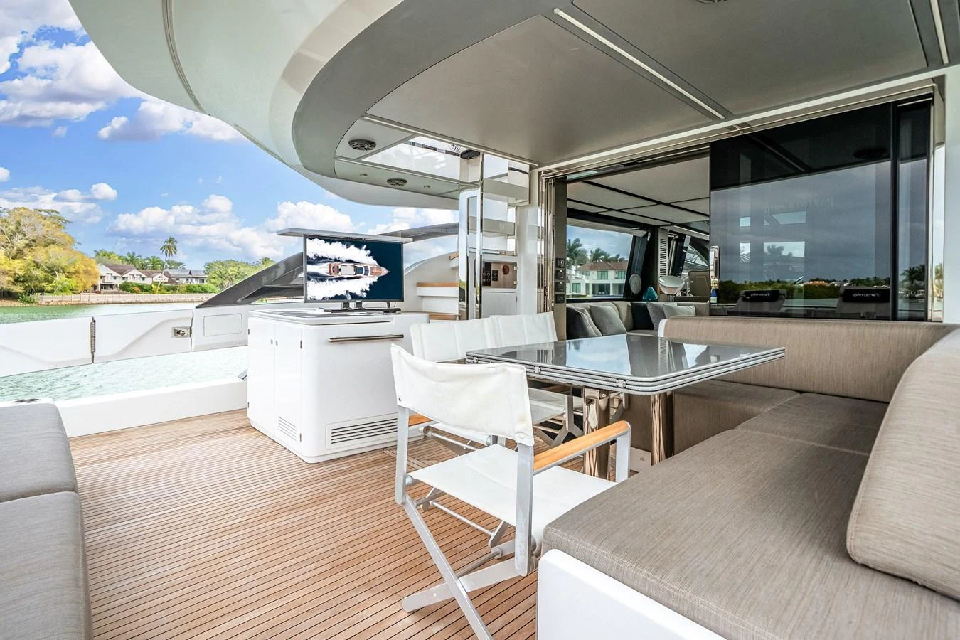 The aft deck features a comfortable seating area with a dining table and a view of the surrounding water. aboard PARTNERSHIP V Yacht for Sale