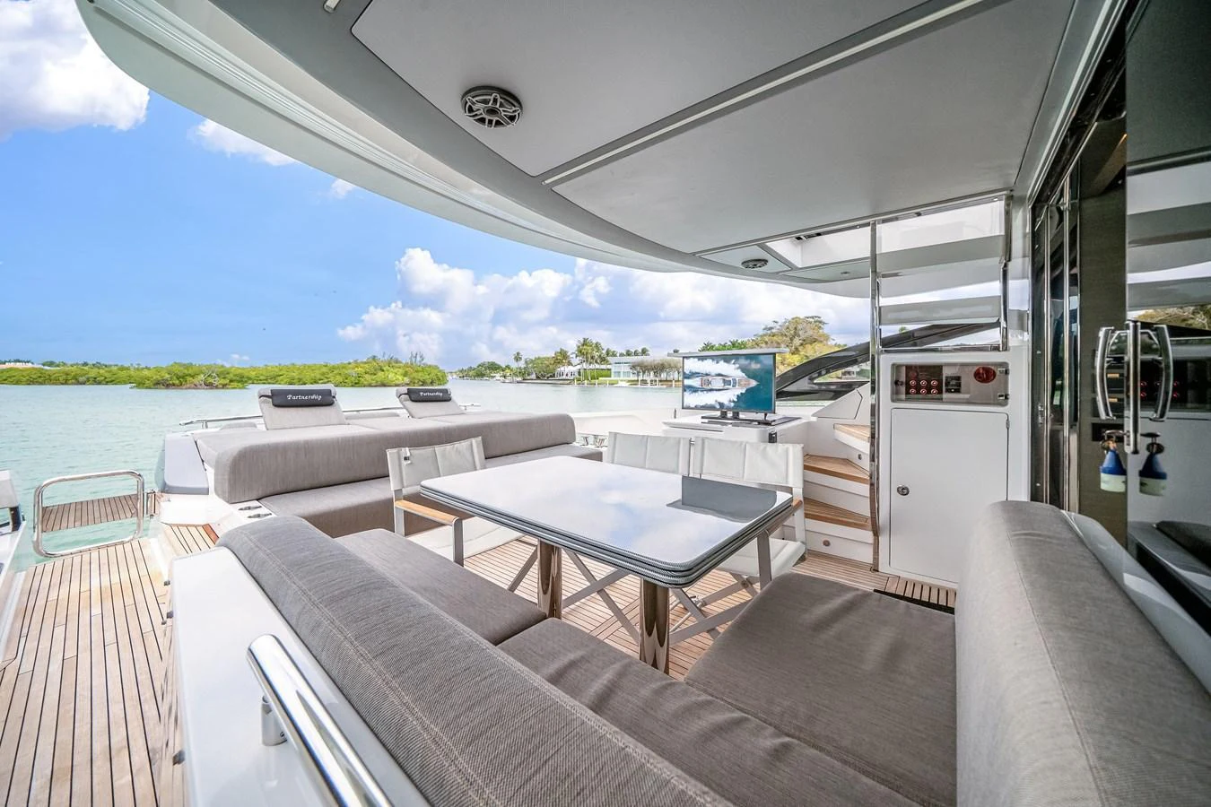 The aft deck features a comfortable seating area with a dining table, perfect for enjoying meals with a view. aboard PARTNERSHIP V Yacht for Sale