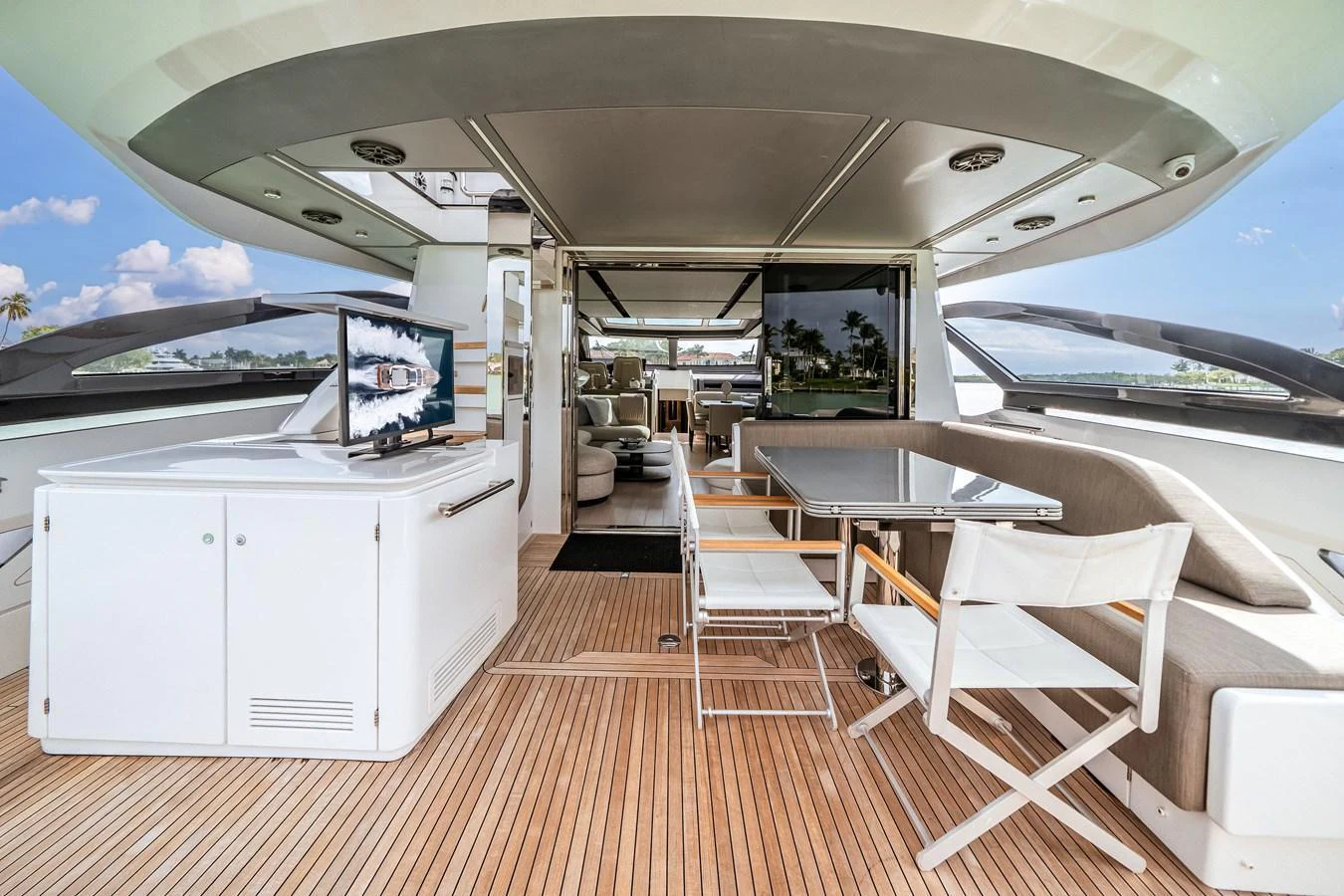 The aft deck features a spacious seating area with a dining table and a built-in entertainment system, perfect for alfresco dining and relaxation. aboard PARTNERSHIP V Yacht for Sale