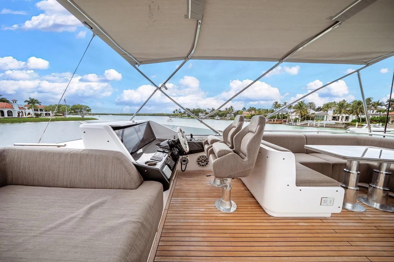 The flybridge offers a spacious and comfortable area with ample seating and a helm station under a protective canopy. aboard PARTNERSHIP V Yacht for Sale