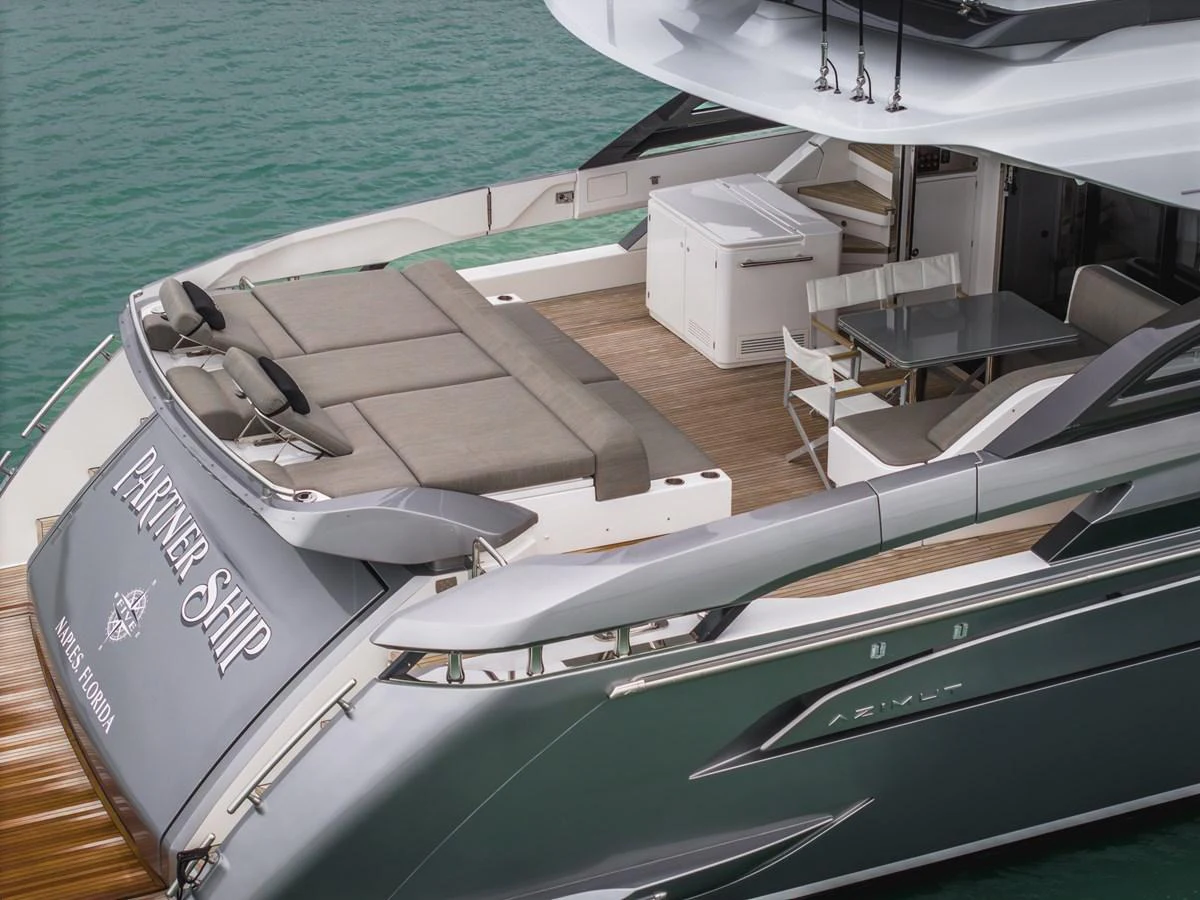 The aft deck features a spacious lounging area with comfortable seating and a dining table, perfect for outdoor relaxation and meals. aboard PARTNERSHIP V Yacht for Sale