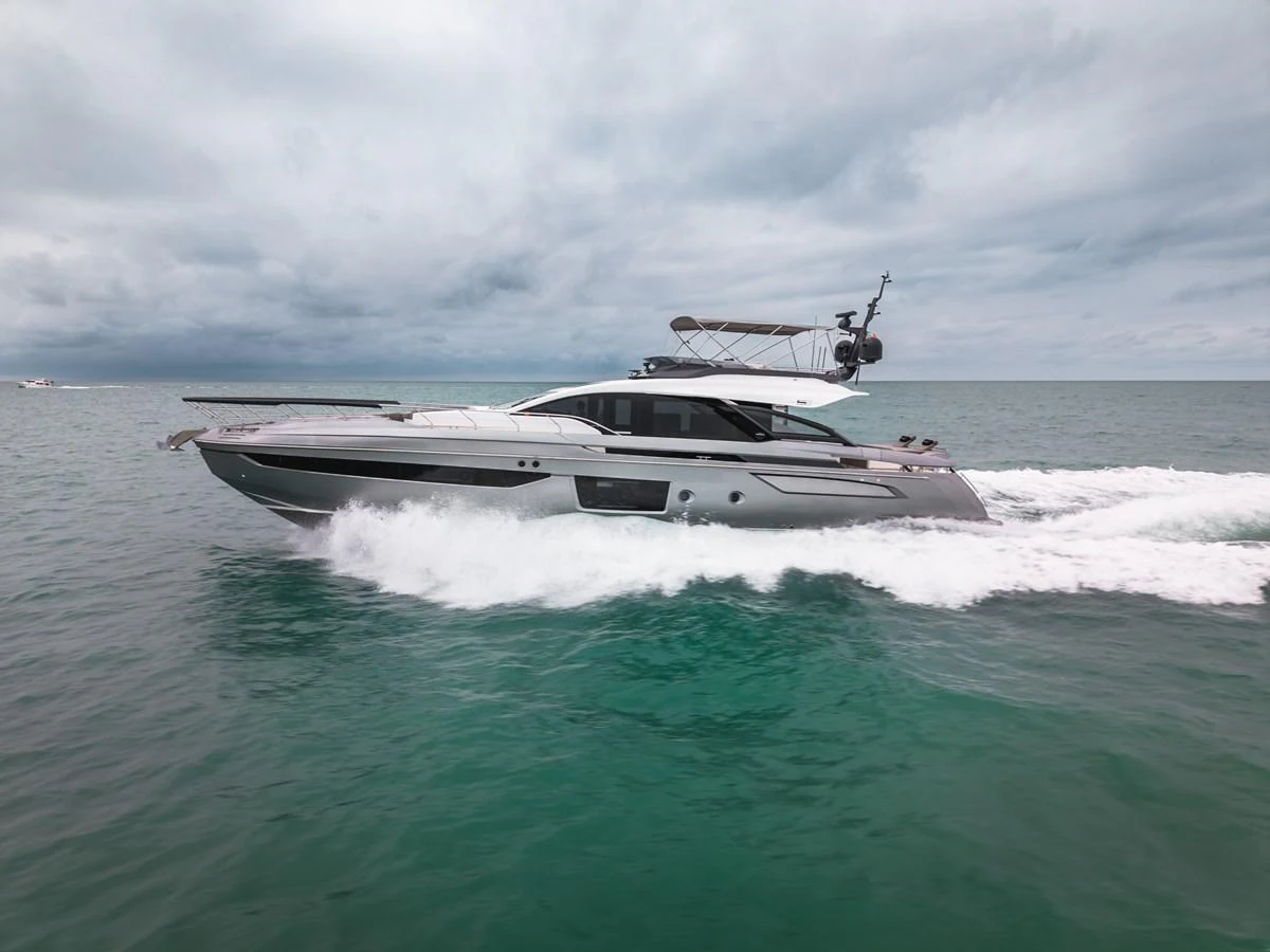 A sleek and modern yacht cruises swiftly through the open water under a cloudy sky. aboard PARTNERSHIP V Yacht for Sale