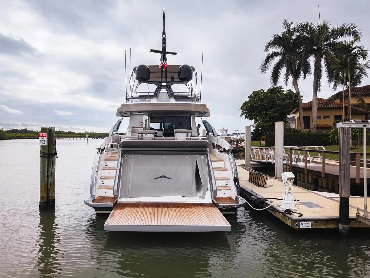 The yacht is docked at a marina, showcasing its spacious stern with an extended swim platform. aboard PARTNERSHIP V Yacht for Sale