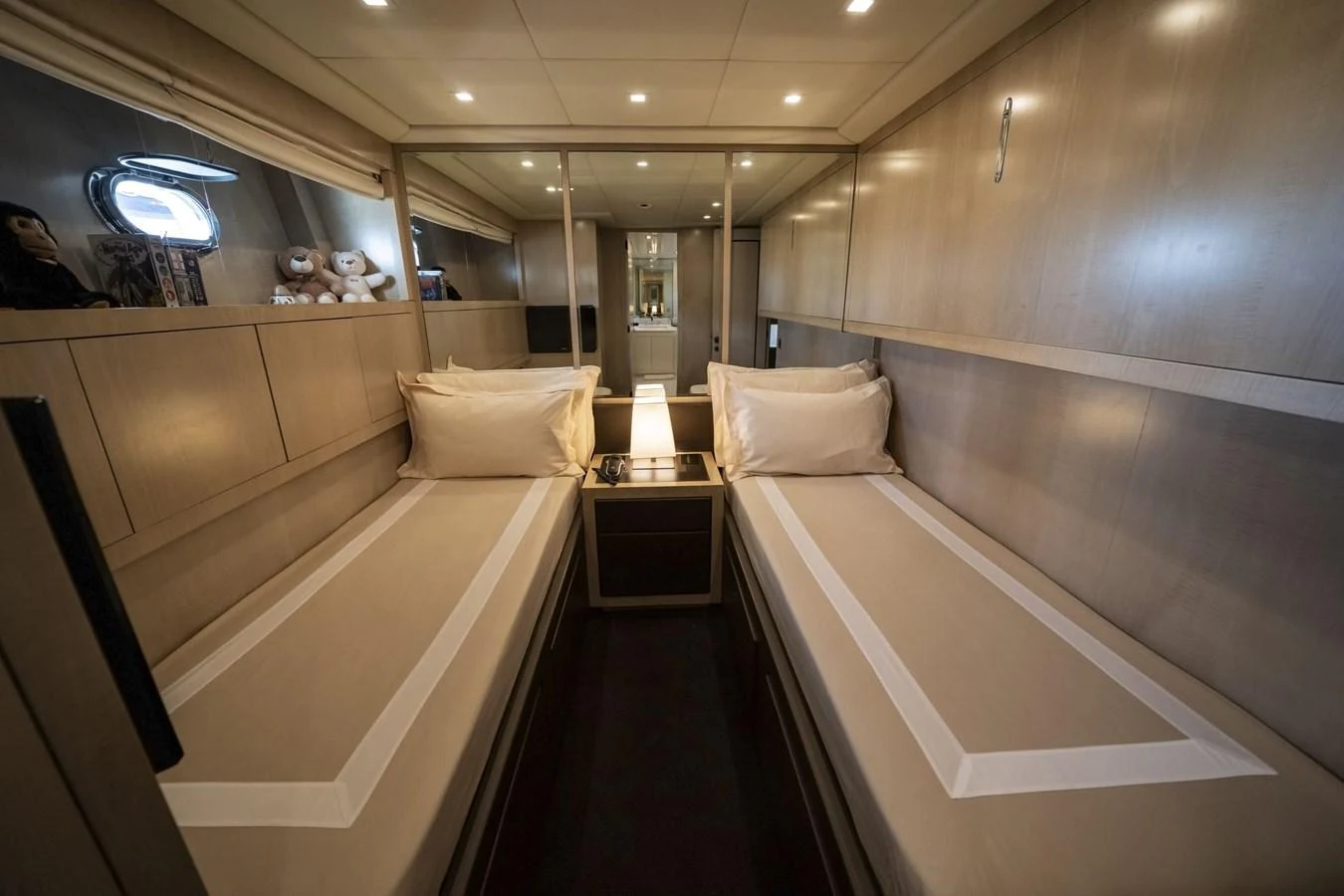 A cozy twin stateroom with modern furnishings and soft lighting. aboard MANU Yacht for Sale