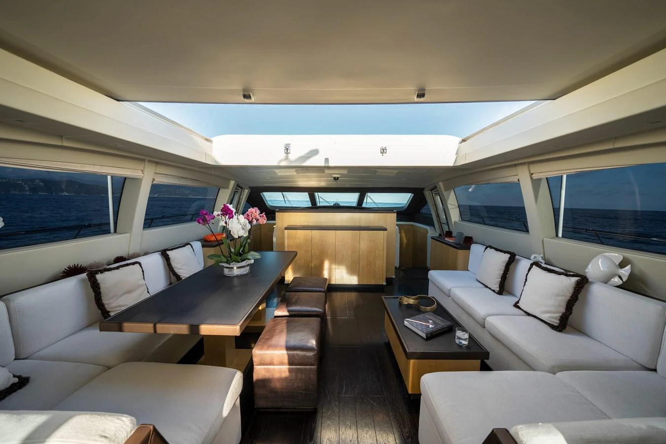 The salon features a spacious and luxurious seating area with panoramic windows offering stunning sea views. aboard MANU Yacht for Sale