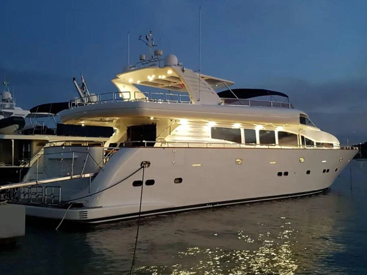 A sleek yacht is illuminated at dusk while docked in the marina. aboard LADY TATIANA Yacht for Sale