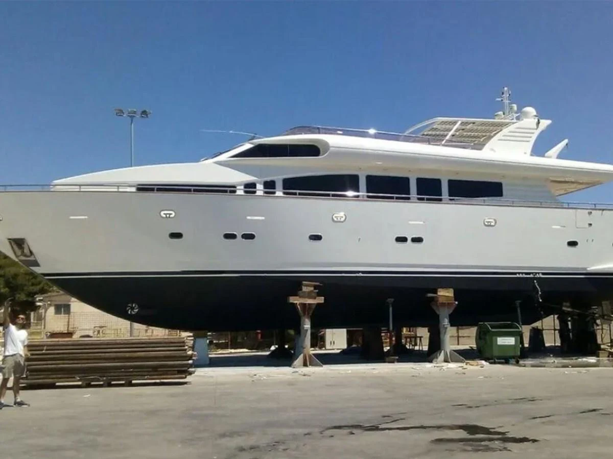A sleek yacht is positioned on dry land, showcasing its elegant design and structure. aboard LADY TATIANA Yacht for Sale