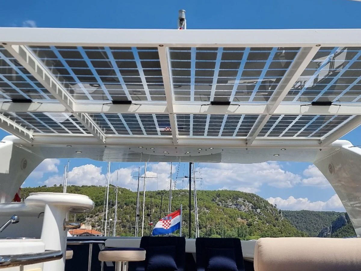 The flybridge features a spacious seating area under a solar panel canopy, offering a blend of comfort and sustainability. aboard LADY TATIANA Yacht for Sale