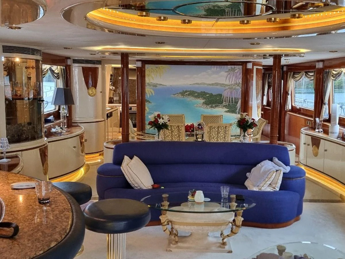 The luxurious salon features elegant furnishings and a scenic mural, creating a sophisticated and inviting atmosphere. aboard LADY TATIANA Yacht for Sale