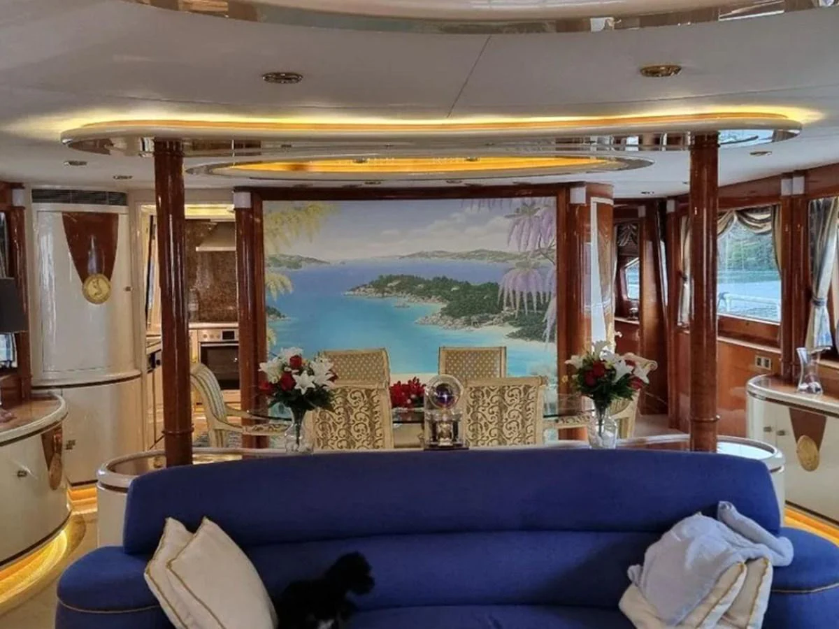 The yacht's interior features a luxurious seating area with a vibrant mural and elegant furnishings. aboard LADY TATIANA Yacht for Sale