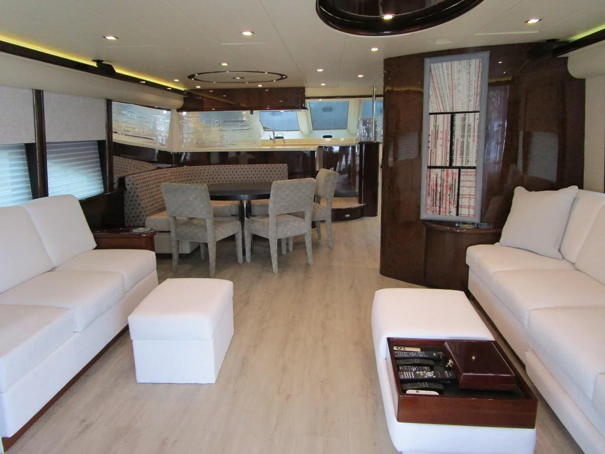 The salon features plush white seating and a dining area with a modern, elegant design. aboard SHORE GIRL Yacht for Sale