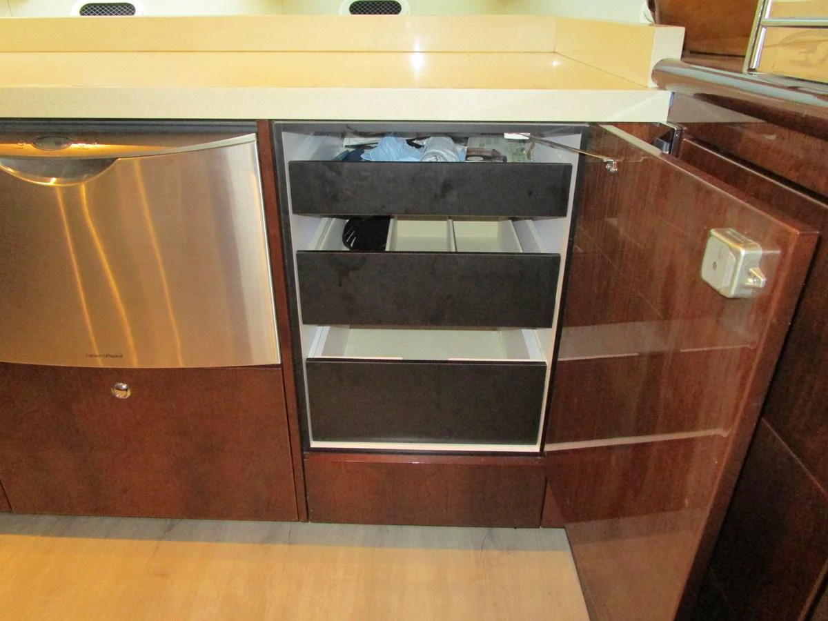 The galley features modern cabinetry with open drawers and a stainless steel dishwasher. aboard SHORE GIRL Yacht for Sale