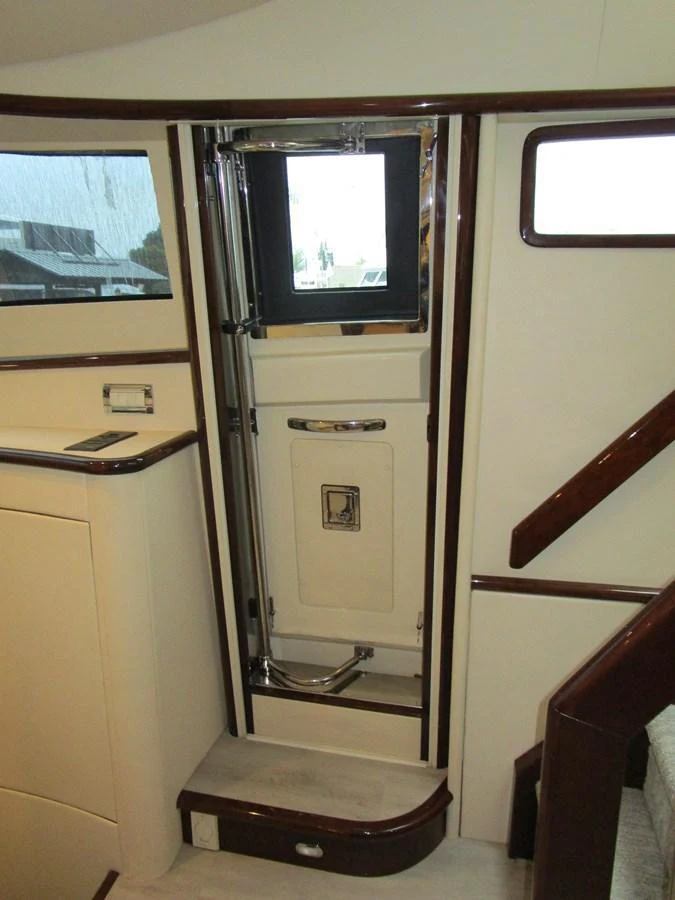A well-crafted interior stairway with polished wood accents and a small window. aboard SHORE GIRL Yacht for Sale