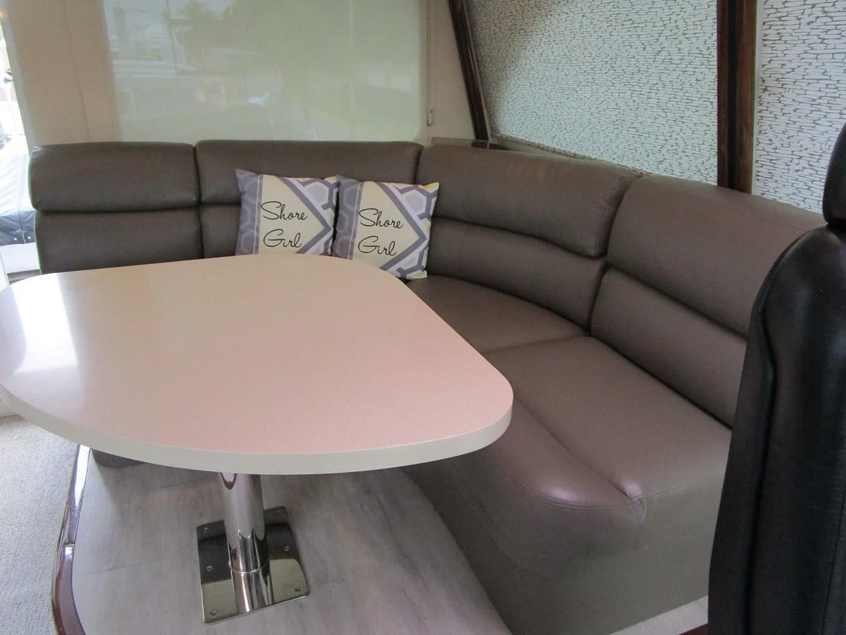 The salon features a comfortable seating area with a modern table and stylish cushions. aboard SHORE GIRL Yacht for Sale