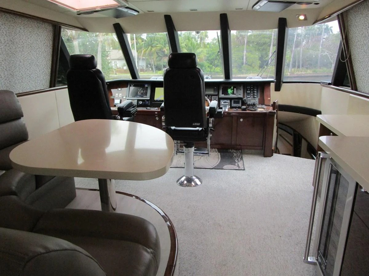 The helm station features modern navigation equipment and comfortable seating, offering a commanding view for the captain. aboard SHORE GIRL Yacht for Sale