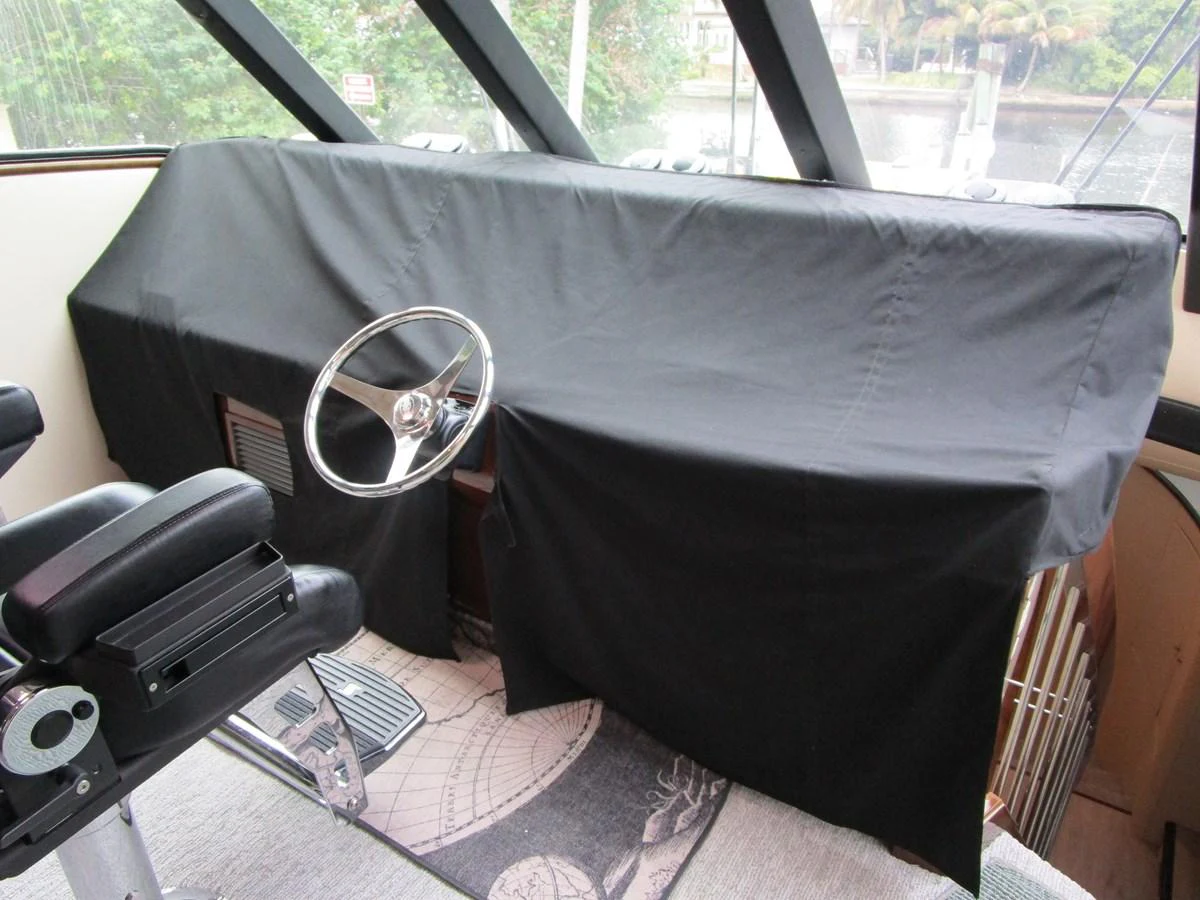 The yacht's helm is covered, showcasing a sleek steering wheel and a comfortable captain's chair. aboard SHORE GIRL Yacht for Sale