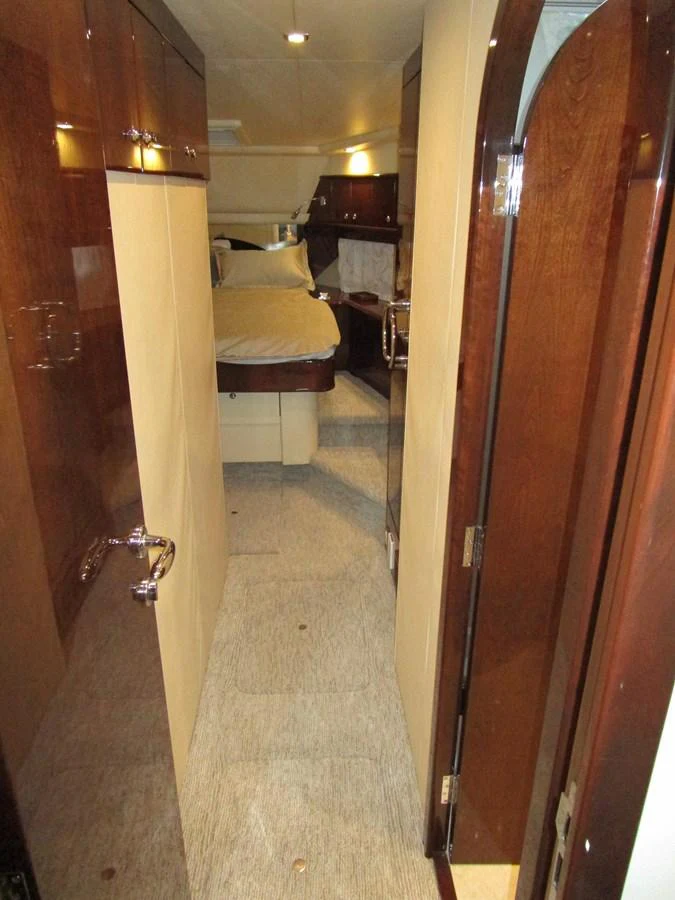 A cozy hallway leads to a well-appointed stateroom with warm wood finishes. aboard SHORE GIRL Yacht for Sale