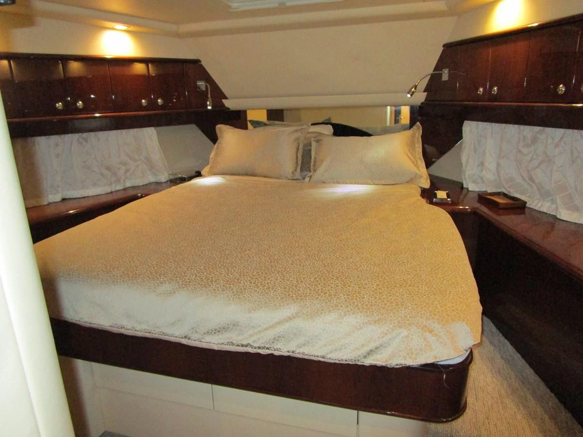 A cozy stateroom with a large bed and elegant wood finishes. aboard SHORE GIRL Yacht for Sale
