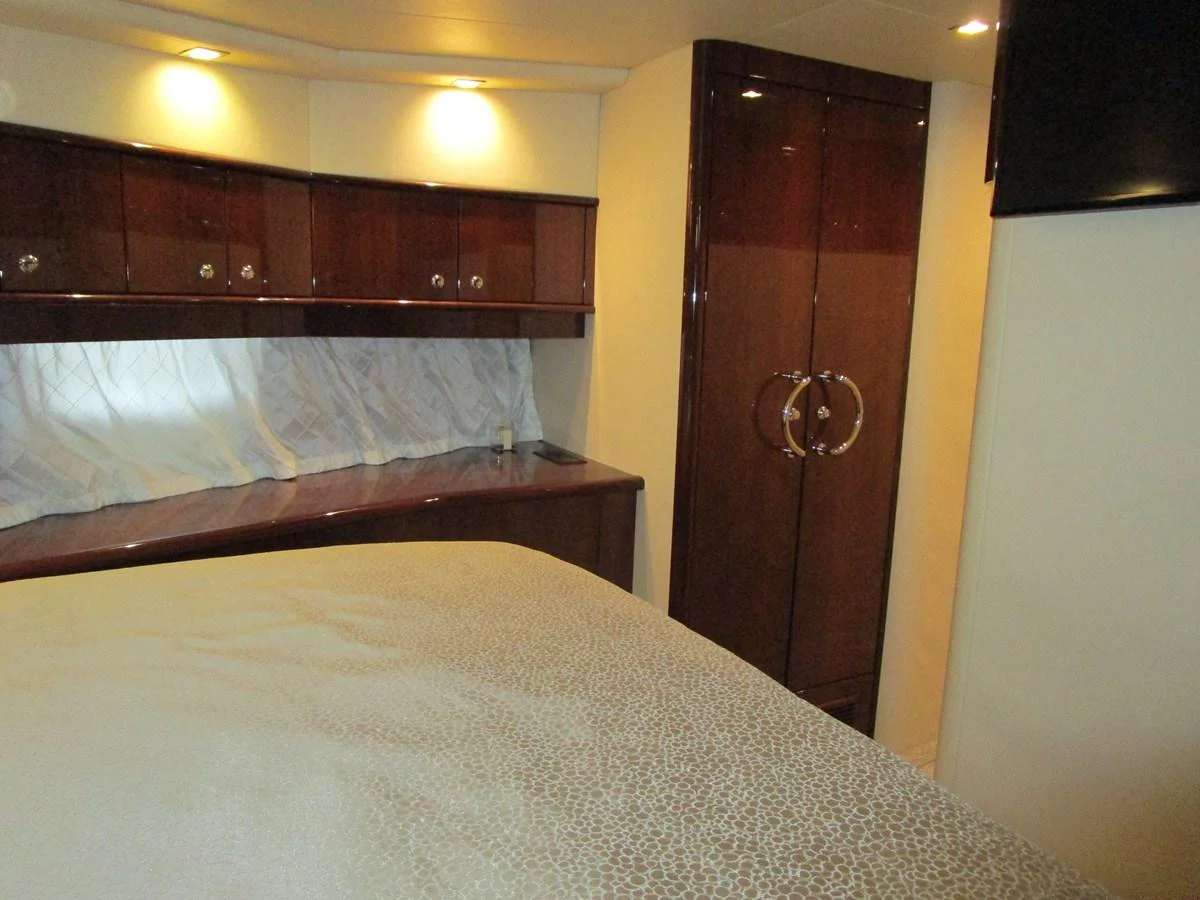 This cozy stateroom features elegant wood cabinetry and a comfortable bed. aboard SHORE GIRL Yacht for Sale