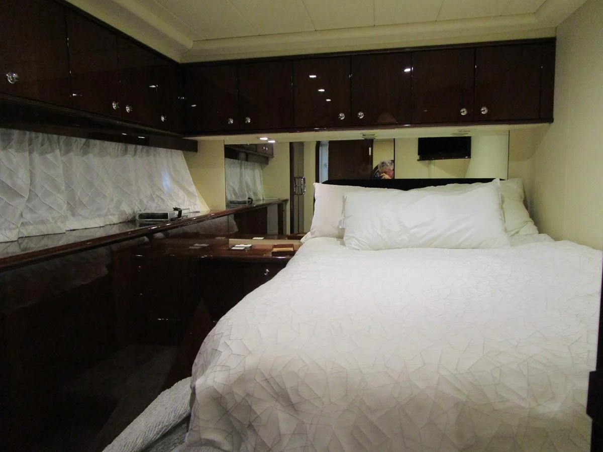 A cozy stateroom featuring a comfortable bed with white linens and ample storage space. aboard SHORE GIRL Yacht for Sale