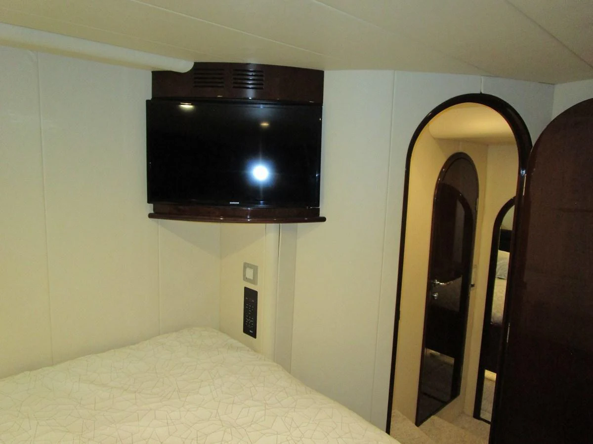 A cozy stateroom featuring a wall-mounted TV and a comfortable bed. aboard SHORE GIRL Yacht for Sale