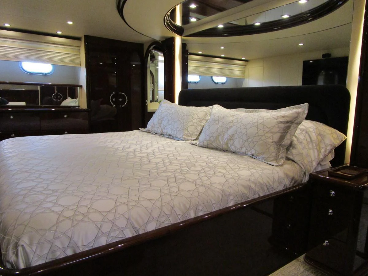 The master stateroom features a luxurious bed with elegant bedding and ambient lighting. aboard SHORE GIRL Yacht for Sale