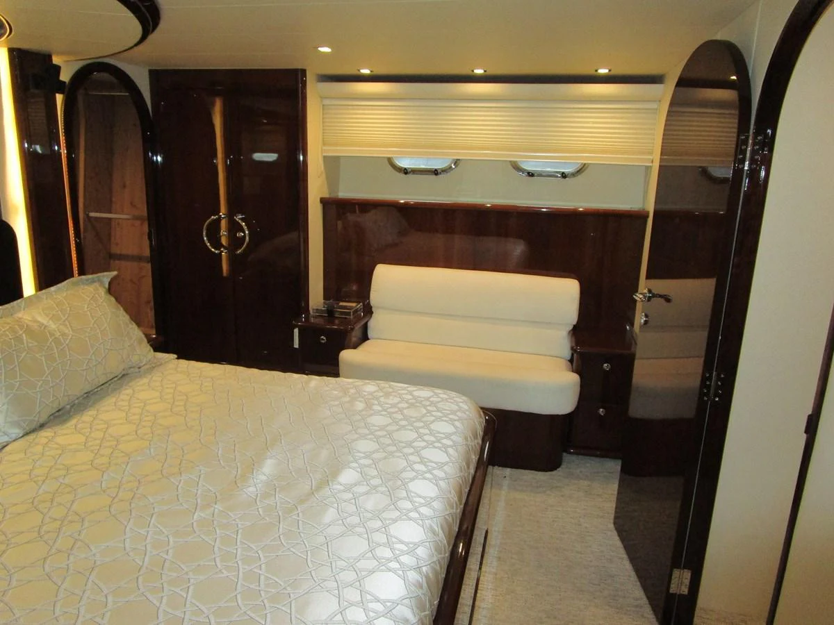 The stateroom features a plush bed, elegant wood finishes, and ample lighting for a cozy retreat. aboard SHORE GIRL Yacht for Sale